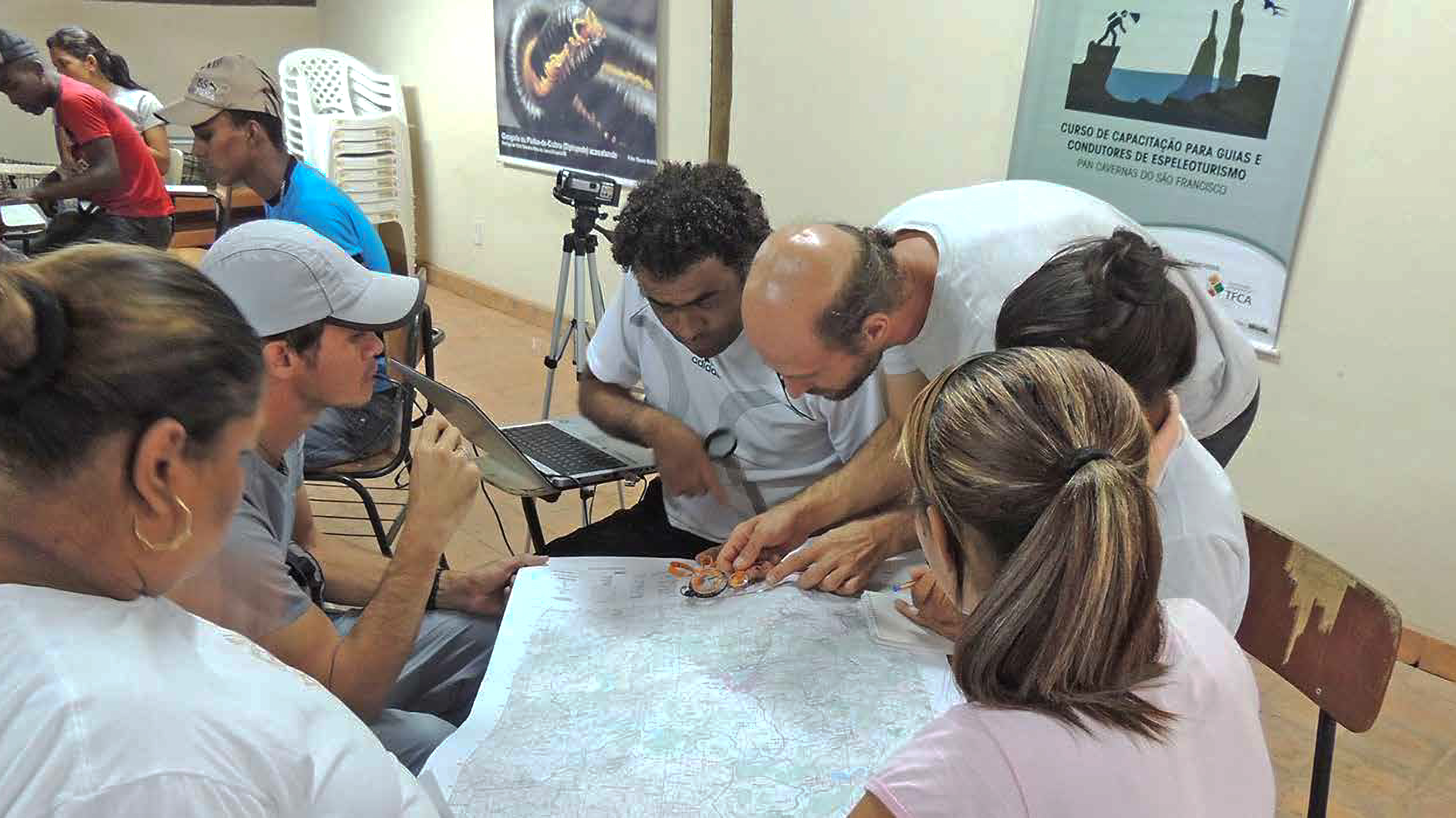 Edner Brasil ensinado o uso da bússola sobre o mapa na aula de cartografia e orientação no curso de competências mínimas